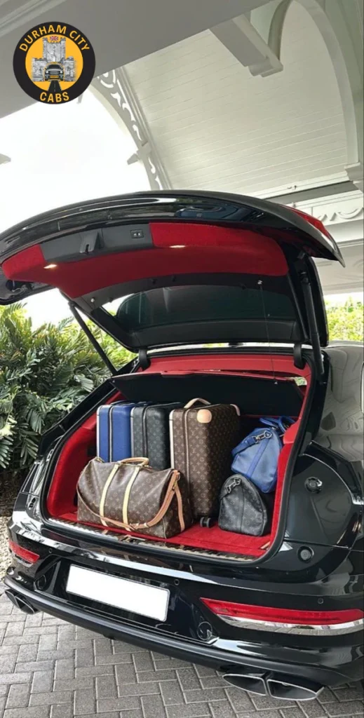 A car's spacious boot filled with multiple large suitcases and travel bags, demonstrating ample luggage capacity for a student moving to university.