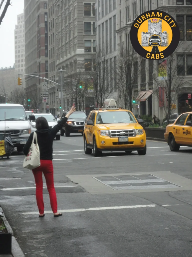 A woman on a busy city street with her hand raised, trying to hail a taxi, illustrating the stress of finding transport when not pre-booked.